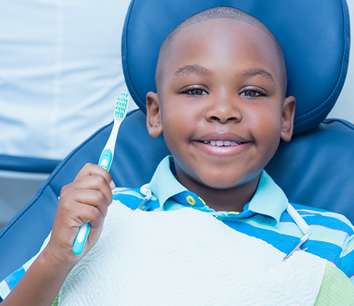 Young boy in dental exam chair smiling