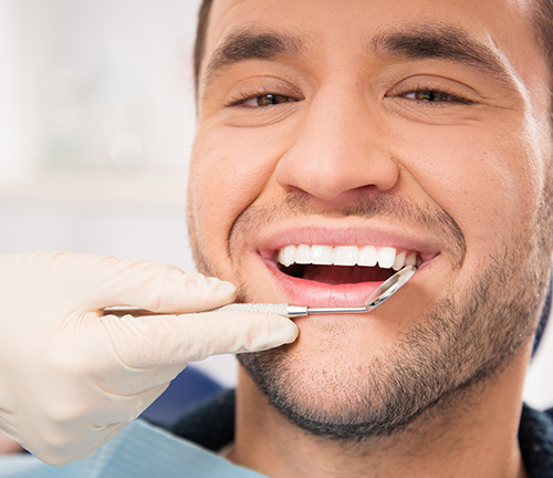 Man receiving teeth cleaning and exam